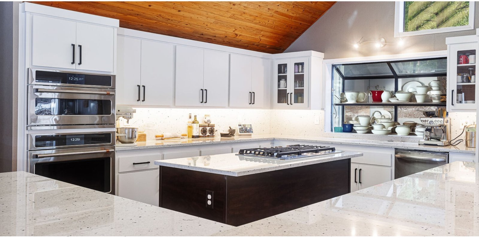 A bright white shaker kitchen with a dark island