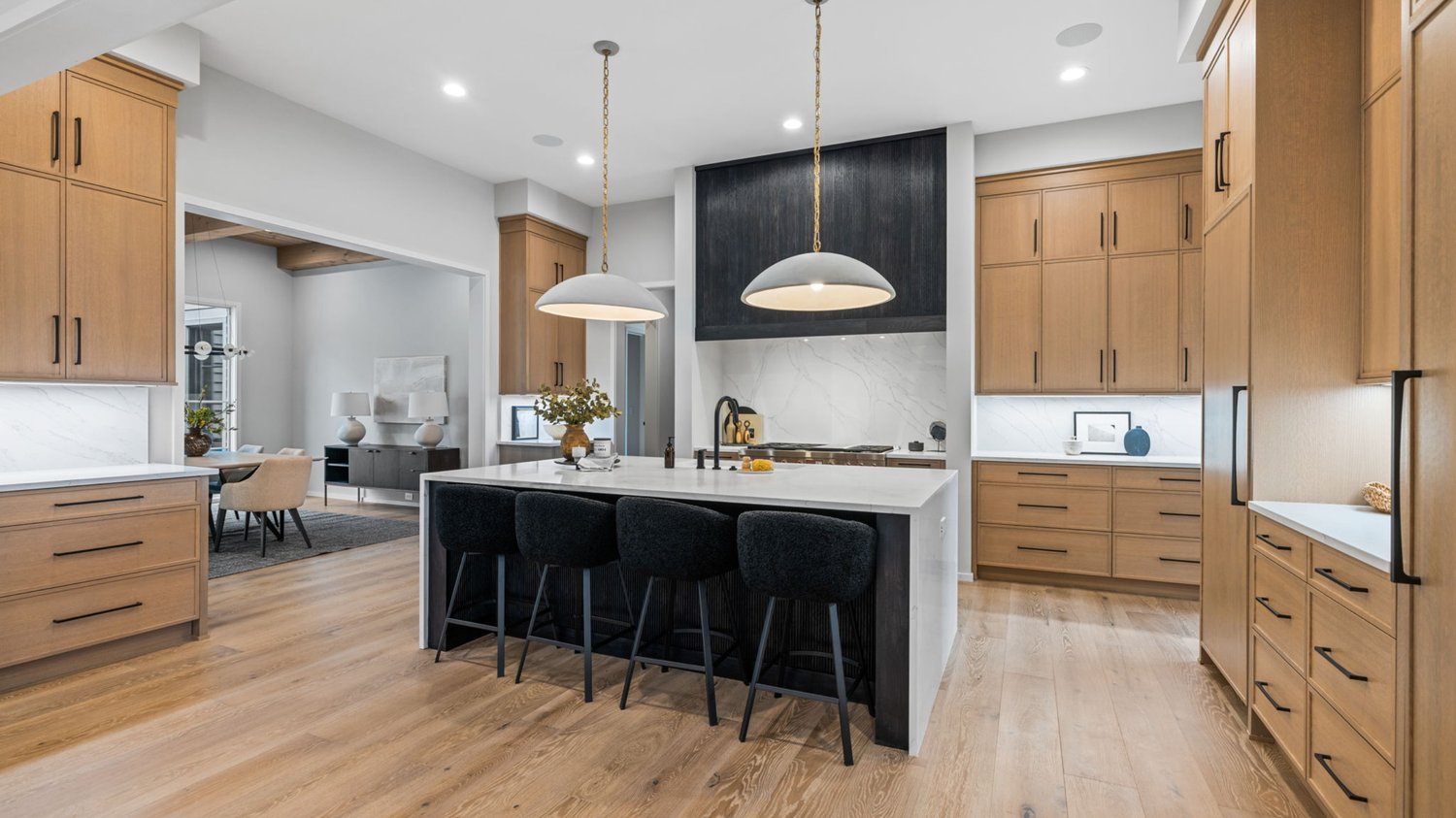 Natural oak kitchen with a black hood and white stone island