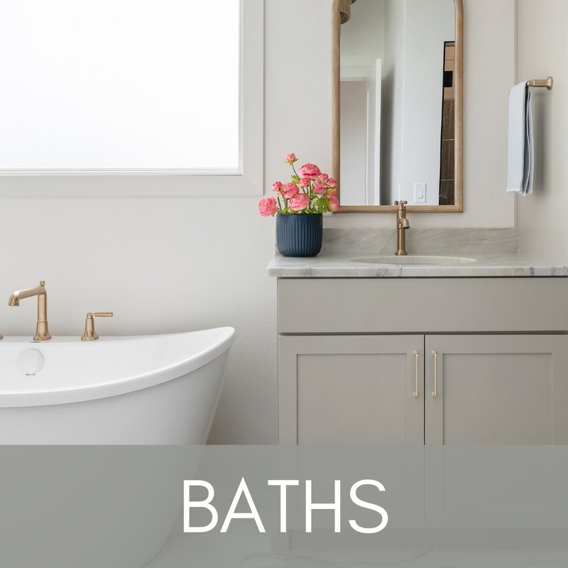 Greige bathroom vanity with brass fixtures and white tub