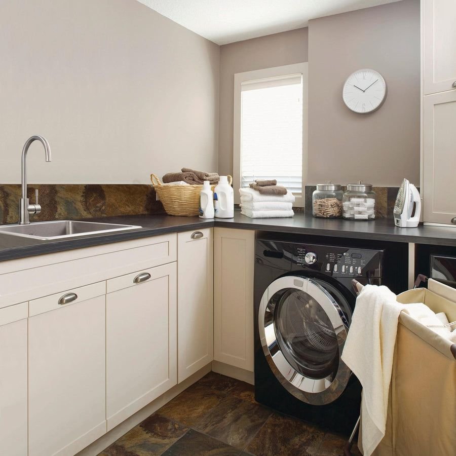 Warm beige laundry room with dark counters and black washer