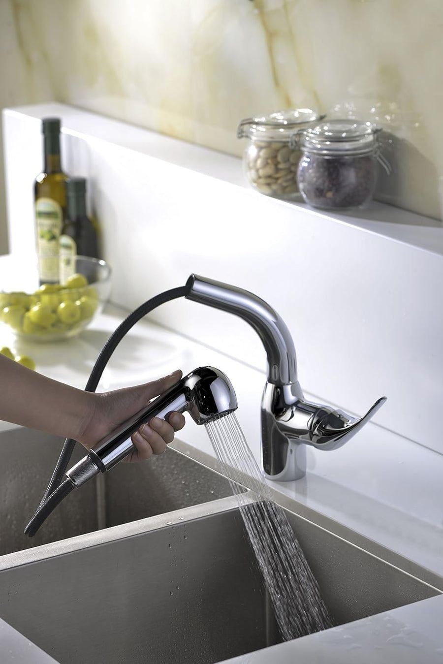Chrome pull-out spray faucet over a deep grey kitchen sink