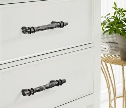 White cabinet drawers with faceted dark metal pulls