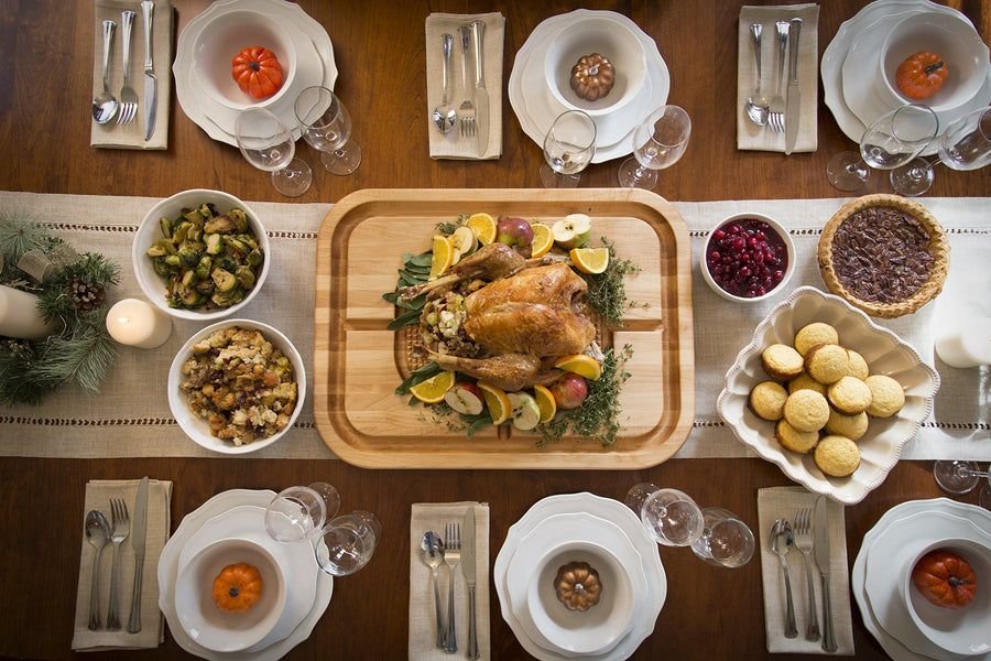 Wood carving board with roast turkey on a festive table