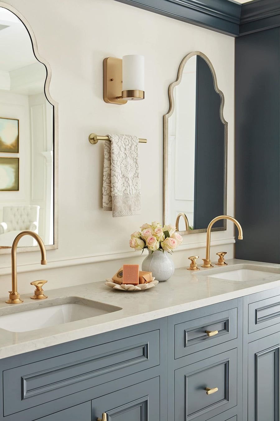 Cool gray double vanity with brass faucets and scalloped mirrors