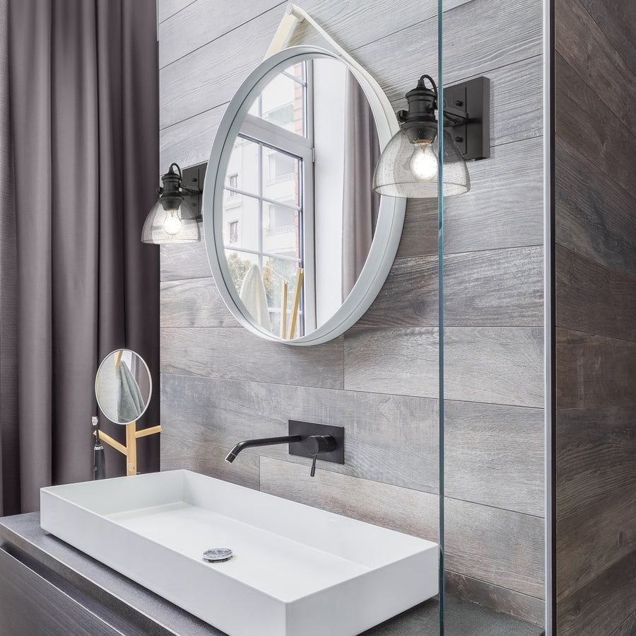 Cool gray plank bathroom with black seeded-glass vanity lights