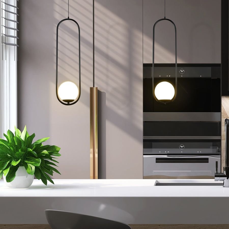 Cool gray kitchen with black oval pendant lights and brass accents