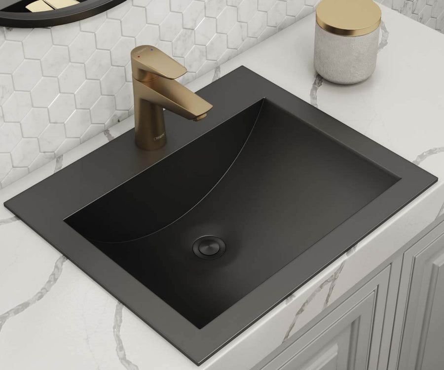 Gunmetal black drop-in sink with a warm brass faucet
