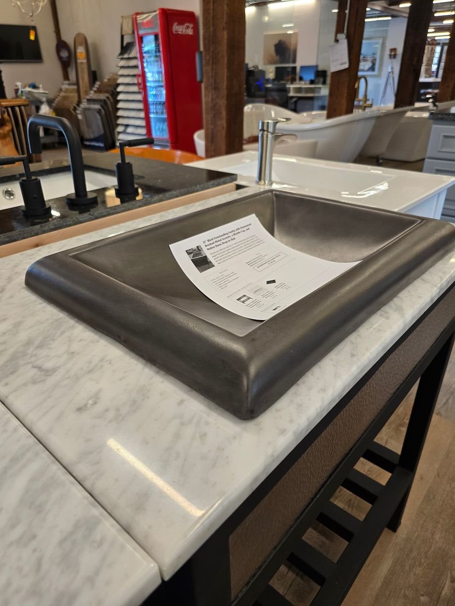 Dark hammered-metal vessel sink on a white marble vanity