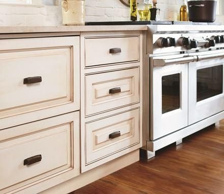 Cream inset kitchen cabinets with dark bronze pulls and white range