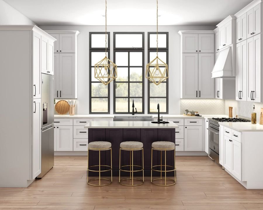 A white shaker kitchen with a dark island, bar stools and brass pendant lights