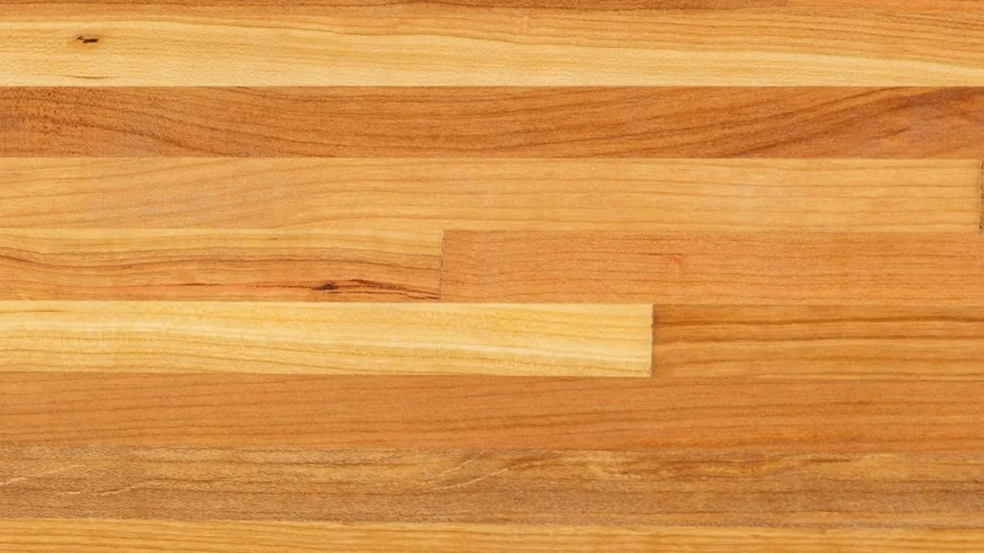 A kitchen island topped with a warm wood butcher block countertop