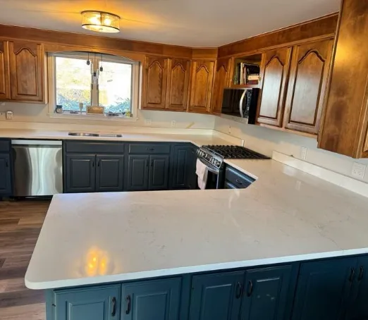 White quartz counters over teal-painted lower cabinets