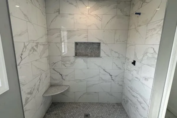 A marble-look tiled bathroom with a heated floor